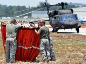 UH-60 Black Hawk crewmembers prepare a collapsible water bucket Florida National Guard aviation crewmembers prepare a water bucket to hook to a Black Hawk helicopter.