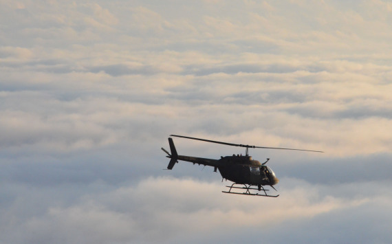 An OH-58 Kiowa helicopter flies above the clouds during the Kiowa's final Florida Army National Guard flight over Florida, Oct. 31, 2014. Photo by 2nd Lt. Justin Phillips
